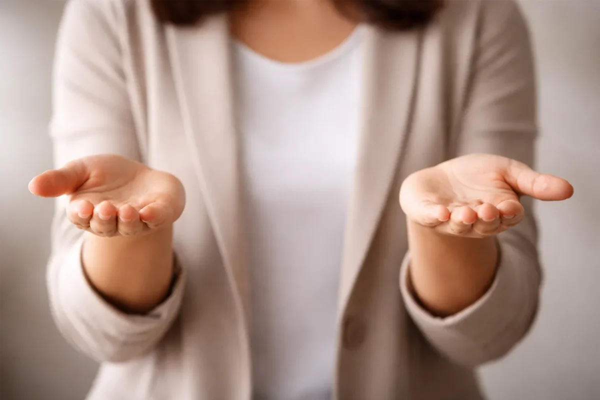 Persona che bilancia oggetti simbolici con le mani in equilibrio
